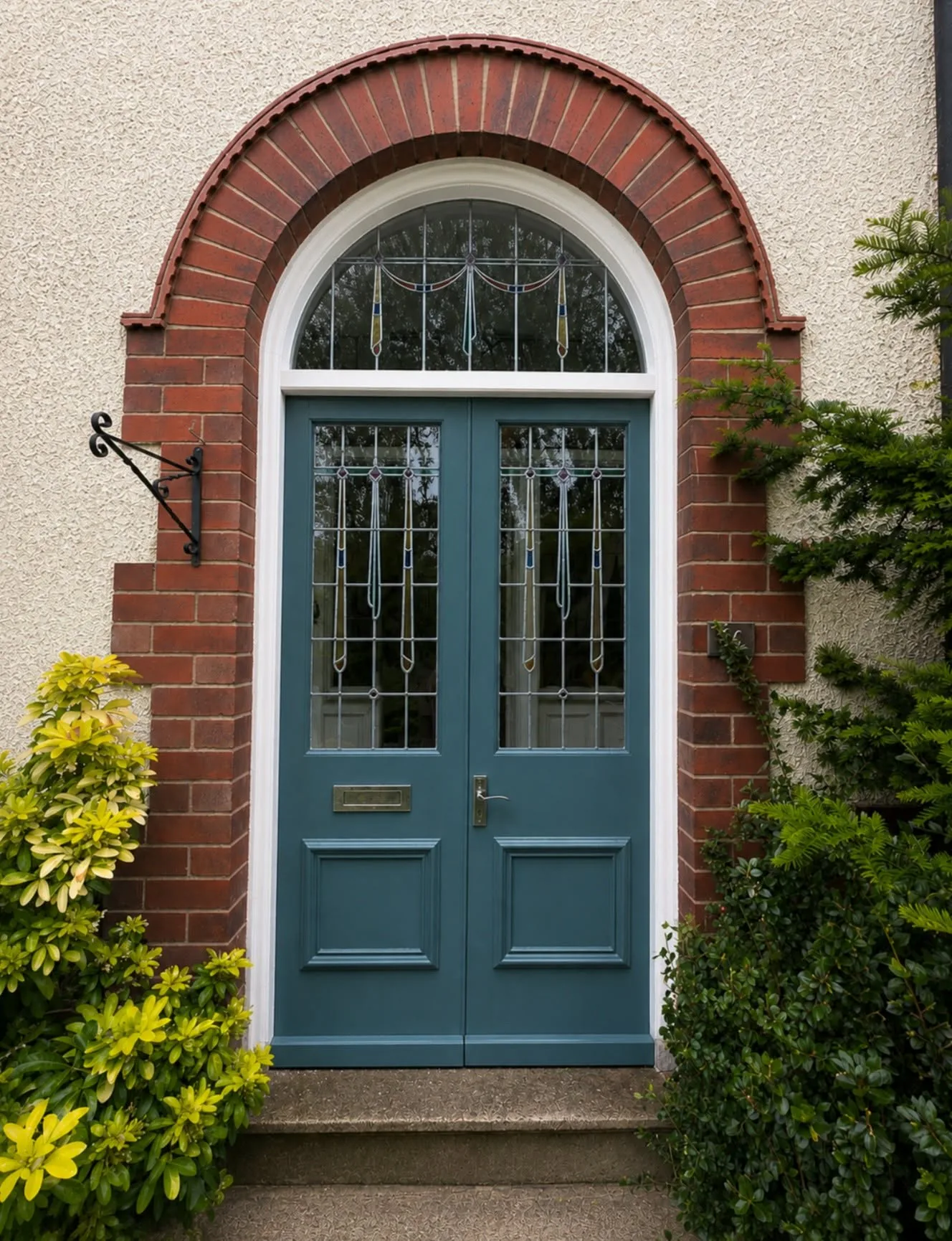 Same arched double entrance doors after repainting in deep blue-green