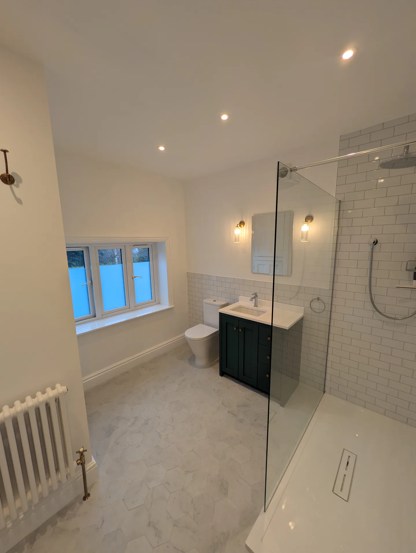Finished pale bathroom with a walk-in shower, dark vanity unit and tiled floor
