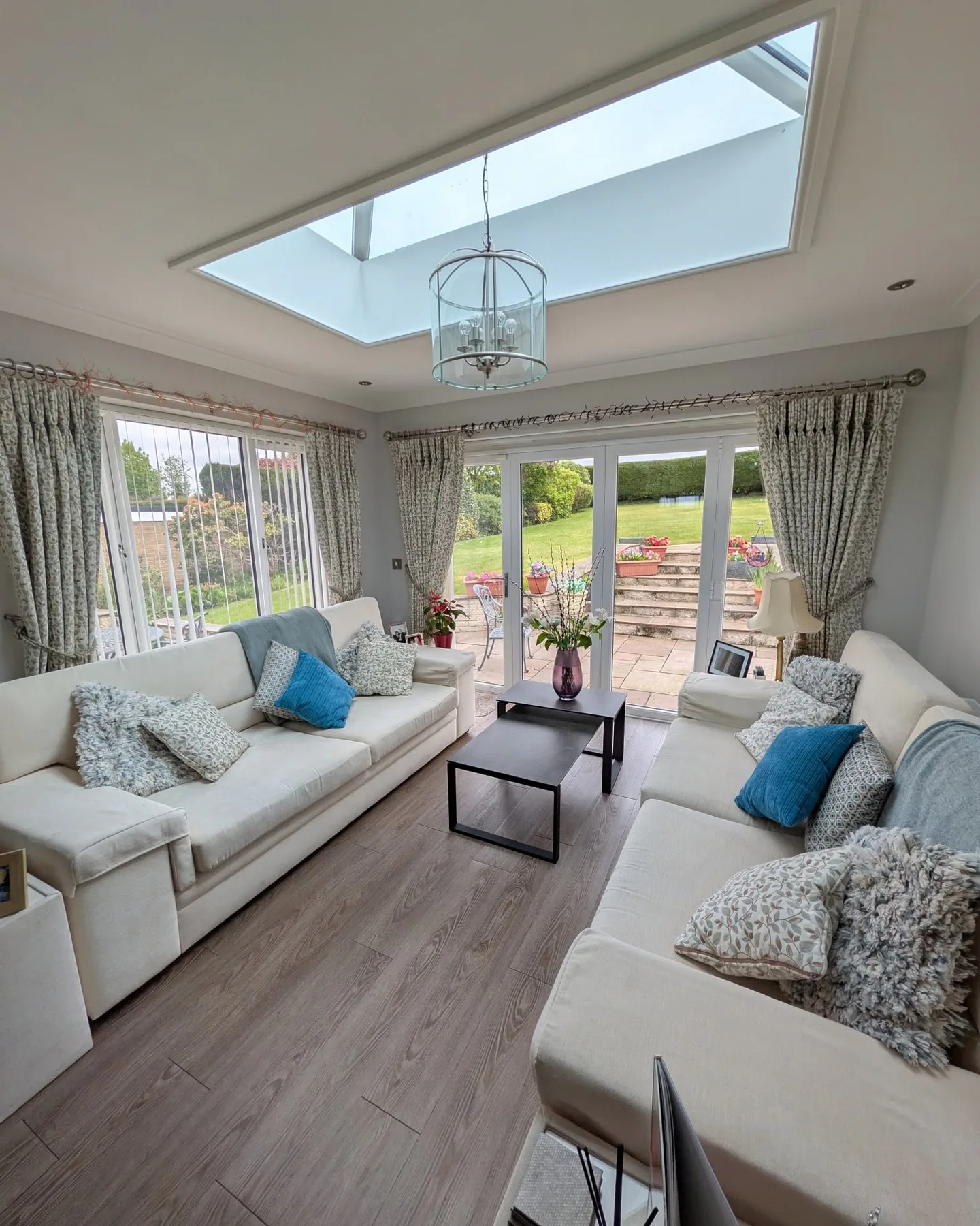 Light garden room with grey walls, pale sofas, skylight and garden doors